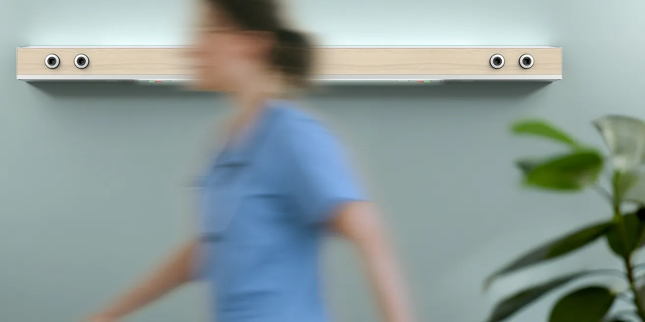 A nurse walks down a bright hospital corridor.